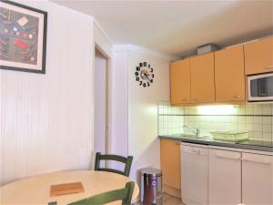 une cuisine avec une table et une horloge murale dans l'établissement Studio du Golf by Interhome, à Saint Cyprien Plage
