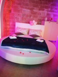 a bed in a room with a pink lighting at Relax Santa Cecilia in Gravina in Puglia