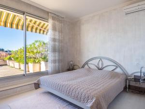 - une chambre avec un lit et une grande fenêtre dans l'établissement Apartment Les Balcons d'Eze by Interhome, à Èze