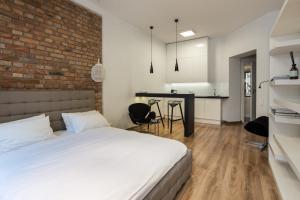 a bedroom with a bed and a brick wall at Apartament Centrum HGa - Garbary in Poznań