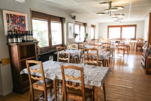 una sala da pranzo con tavoli, sedie e bottiglie di vino di HOTEL SPORTING a Breuil-Cervinia
