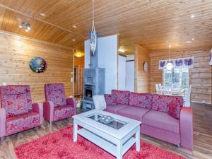 uma sala de estar com um sofá e duas cadeiras e uma mesa em Holiday Home Kolin mesikämmen by Interhome em Kolinkylä