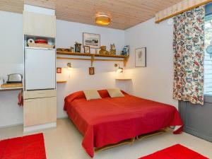 コリンカイラにあるHoliday Home Loma-koli 1 by Interhomeの赤いベッドと冷蔵庫付きのベッドルーム1室が備わります。