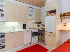 コリンカイラにあるHoliday Home Loma-koli 1 by Interhomeの小さなキッチン(白い家電製品、赤い敷物付)