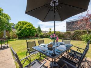 a table with an umbrella on a patio at Holiday Home Preston by Interhome in Paignton