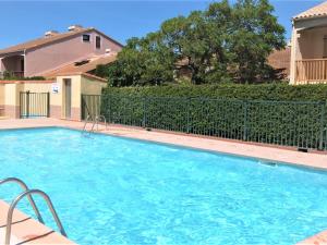 duży niebieski basen przed ogrodzeniem w obiekcie Holiday Home Le Hameau du Rivage by Interhome w mieście Saint-Cyprien