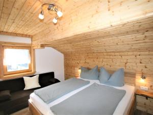 a bedroom with a bed and a wooden wall at Apartment Unterflöber-3 by Interhome in Großhartberg