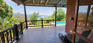 une terrasse en bois avec vue sur la piscine dans l'établissement Da Gama Lake Cottages - Coral Tree and Cormorant Cottages, à White River