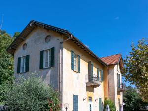 an old building with green shutters and a blue sky at Apartment Vittoria by Interhome in Ghiffa
