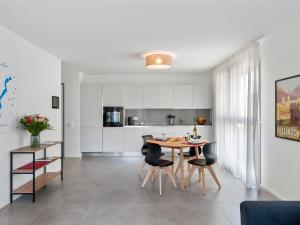 a kitchen and dining room with a table and chairs at Apartment LocTowers A4-2-3 by Interhome in Locarno