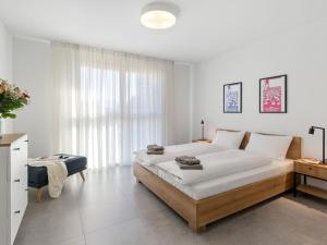 ein Schlafzimmer mit einem großen Bett und einem großen Fenster in der Unterkunft Apartment LocTowers A4-2-3 by Interhome in Locarno