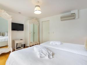 2 letti bianchi in una stanza con specchio di Apartment Le Belvédère D3-8 by Interhome a Montreux