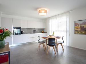 eine Küche und ein Esszimmer mit einem Tisch und Stühlen in der Unterkunft Apartment LocTowers A4-3-4 by Interhome in Locarno