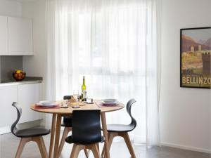 uma mesa de jantar e cadeiras numa cozinha em Apartment LocTowers A4-3-1 by Interhome em Locarno
