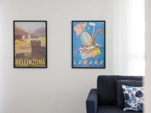 twee ingelijste posters aan een muur naast een bank bij Apartment LocTowers A4-4-3 by Interhome in Locarno