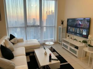 a living room with a white couch and a flat screen tv at Torch 77 in Dubai