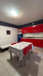 カヴァッリーノ・トレポルティにあるApartaments Marina del Cavallinoの赤いキャビネットとテーブル付きのキッチンが備わります。