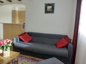 a living room with a blue couch with red pillows at Apartment Barzettes-Vacances B-11 by Interhome in Crans-Montana
