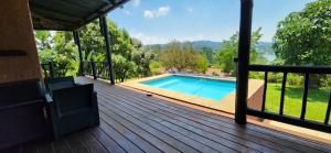 a deck with a swimming pool on a house at Da Gama Lake Cottages - Coral Tree and Cormorant Cottages in White River