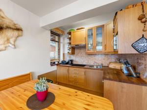 eine Küche mit Holzschränken und einem Holztisch in der Unterkunft Apartment Sachrův Kopec by Interhome in Harrachov