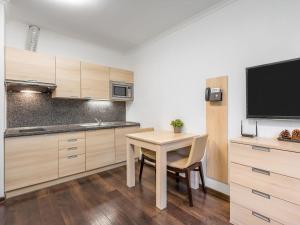 Il comprend une petite cuisine avec une table et une télévision. dans l'établissement Apartment Harrachov Resident Vesna by Interhome, à Harrachov