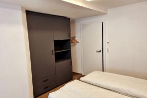 a bedroom with a gray cabinet and a bed at Appartment Wolf Huber im Zentrum der Altstadt. in Feldkirch
