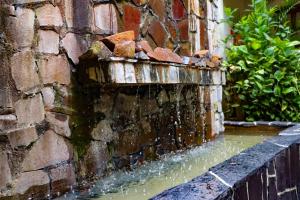 a water fountain on the side of a brick building at Hotel Jardin De Iguazu in Puerto Iguazú