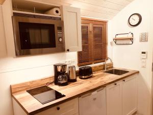 a kitchen with a counter top and a microwave at Zirkuswagen mit Outdoor Whirlpool und Garten in Petershagen