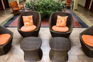 a group of wicker chairs with pillows in a lobby at Hotel Jardin De Iguazu in Puerto Iguazú