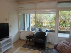 - un salon avec une grande fenêtre et une chaise dans l'établissement Sfeervolle villa in Gasselte Drenthe bij Hemelriek, à Gasselte