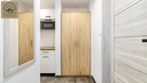 a kitchen with wooden cabinets and a door at Stare Miasto Gdańsk - Marina in Gdańsk