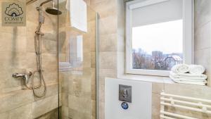 a shower in a bathroom with a window and towels at Stare Miasto Gdańsk - Marina in Gdańsk
