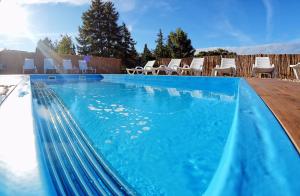 a swimming pool with chairs on a patio at Amberia in Grzybowo