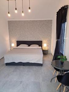 a bedroom with a large bed and two tables at Kevin&Jessica Rooms in Giarmata