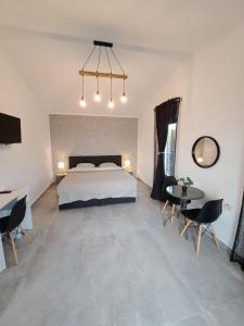 a bedroom with a bed and a table and chairs at Kevin&Jessica Rooms in Giarmata