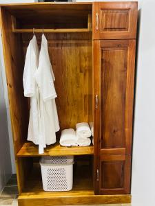 a wooden cabinet with white towels and a basket at SuMin Homestay in Phú Quốc