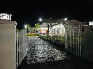 a white fence in front of a garden at night at SuMin Homestay in Phu Quoc