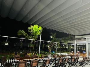 a dining area with tables and chairs at night at SuMin Homestay in Phú Quốc