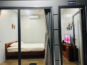 a small bedroom with a bed and a mirror at SuMin Homestay in Phú Quốc