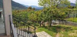 a balcony with a view of a tree and mountains at Maison village Corse in Santa-Maria-Siché
