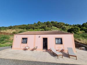een klein roze huis met stoelen en een tafel bij villa los vaqueros in Garafía