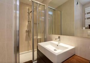 een witte badkamer met een wastafel en een douche bij La Grande Savoyarde in Chamonix-Mont-Blanc +41 foto's