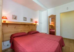 a bedroom with a bed with a red blanket at La Grande Savoyarde in Chamonix