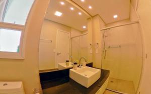 a bathroom with a sink and a toilet and a mirror at Book Santos – Unlimited 1808 c/ Sacada Panorâmica in Santos