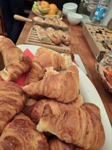 - un plateau de croissants et d'autres viennoiseries sur une table dans l'établissement Logis REX HOTEL Lorient, à Lorient