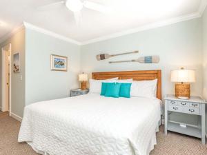 a bedroom with a large white bed with blue pillows at Nautical Watch in Tybee Island