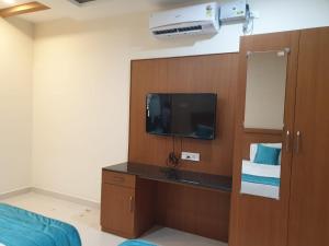 um quarto com uma televisão e um armário com um tvictericter em Kanmani Elite- A Perfect Home em Tiruchchirappalli