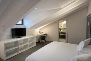 - une chambre avec un lit et un bureau avec une télévision dans l'établissement Boutique Hotel Touring, à Vérone