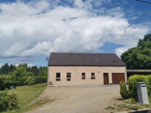 une grande grange blanche avec des fenêtres sur un champ dans l'établissement Mevazara guesthouse, à Malmedy