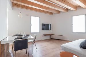 a living room with a white table and chairs at Palazzo '900 Design Flats - Il Poeta in Padova